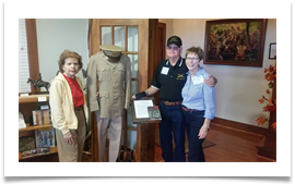 Col. Bill & Karen Tempere pose with Raqui beside Ed's book, uniform and boots Col. Bill & Karen Tempere pose with Raqui beside Ed's book, uniform and boots